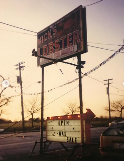 An original Nick's Lobster House sign on Flatbush Avenue that reads "Nick's Lobster: Fresh Fish Market".