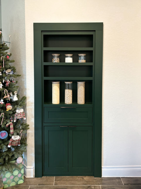 Dark green Sherwin-Williams Olympic Range Murphy door concealing a hidden office, featuring custom shelving and seamless integration. Built for a designer home near San Antonio, TX to blend high design with functionality.