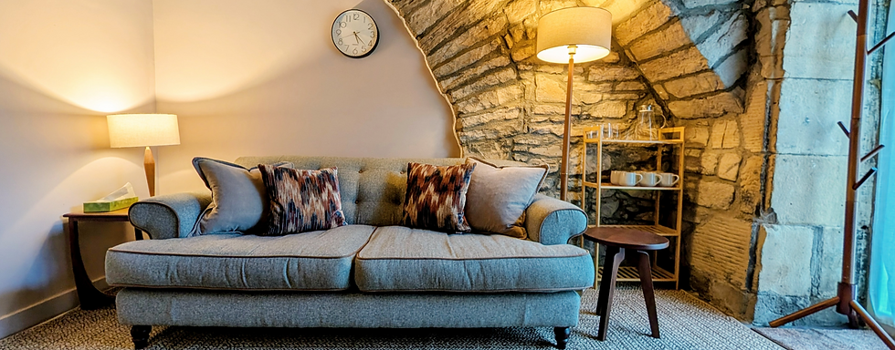 A warm and welcoming therapy room in Edinburgh with stone walls and soft furnishings.