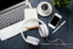 Transcriber's workspace with headphones on a laptop on a desk