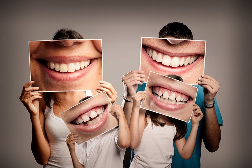 Family holding pictures of smiles