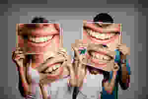 Family holding pictures of smiles