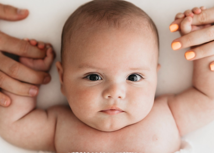 baby holding parents hands
