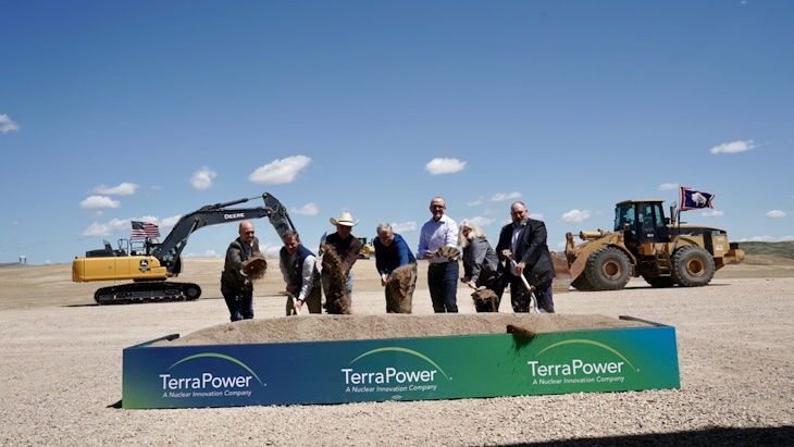 Bill Gates (center) and Wyoming Governor Mark Gordon (in cowboy hat) participate in the groundbreaking ceremony for the TerraPower Natrium nuclear plant in Kemmerer, Wyoming, on June 10, 2024. They are joined by company executives and local officials, tossing dirt with shovels in front of a sign reading 'TerraPower: A Nuclear Innovation Company,' with heavy construction machinery visible in the background