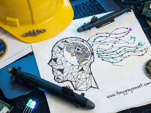 Conceptual flat lay featuring a napkin sketch of a human brain merging with digital circuits, surrounded by a yellow hard hat, submarine models, a Seabees patch, and computer chips.