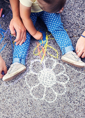 A child drawing a flower in chalk