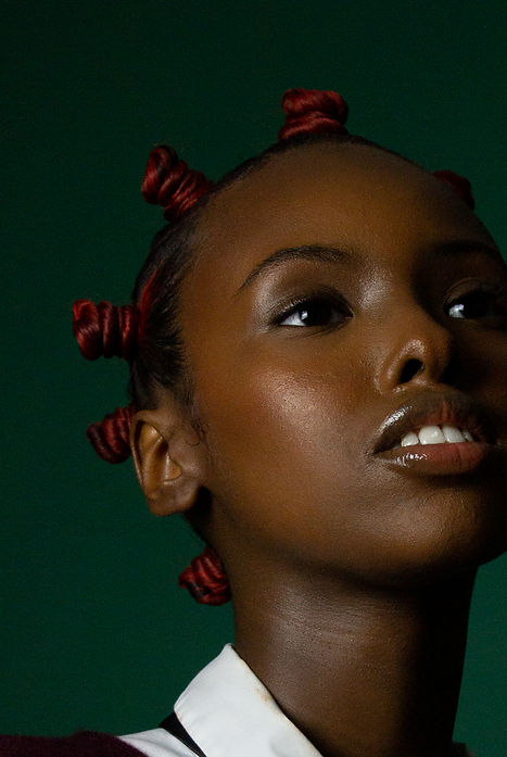 black girl with red bantu knots holding a black tie around her neck photographed by shekinah joseph for kenya's eye magazine