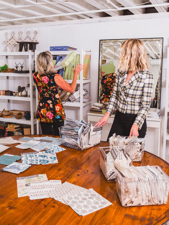 Heron Design House collaborating over fabric and material selections in a curated design studio workspace in Atlanta, Georgia.