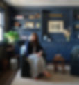 Anne Marie founder of Choux Design seated in office with custom navy blue built-in cabinetry and brass hardware