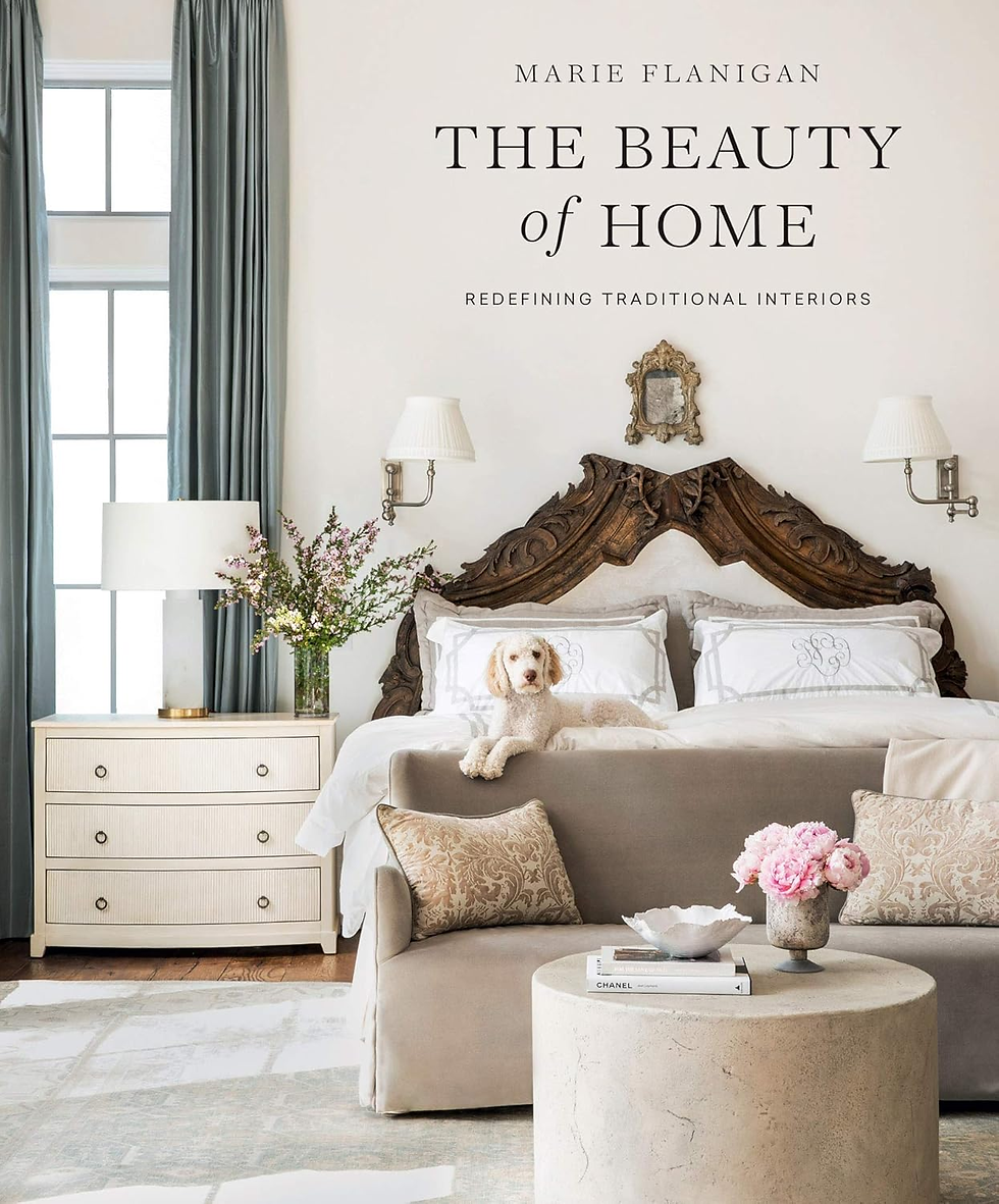 Serene primary bedroom with an upholstered bed, carved wood headboard, and layered neutral furnishings by Marie Flanigan Inte