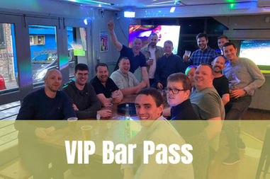 A large group of men smiling and enjoying drinks inside a bar