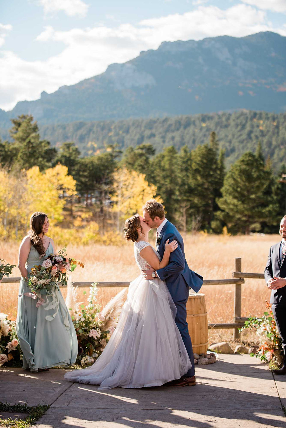 Bride and groom kiss with mountain view at the Wild Basin Lodge