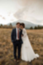 The bride and groom snuggle together as they pose in front of Mount Meeker at View of the rustic, high design reception area at the Ranchstead Inn in Allenspark, CO