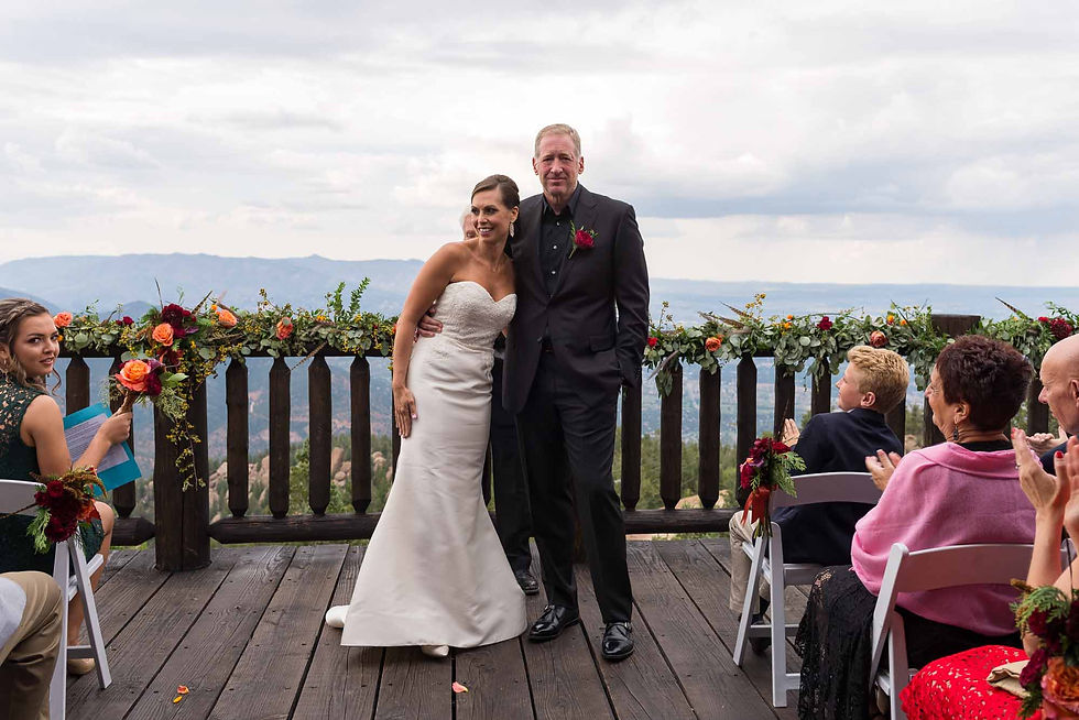 Bride and groom pose together on the outdoor deck at Cloud Camp at the Broadmoor