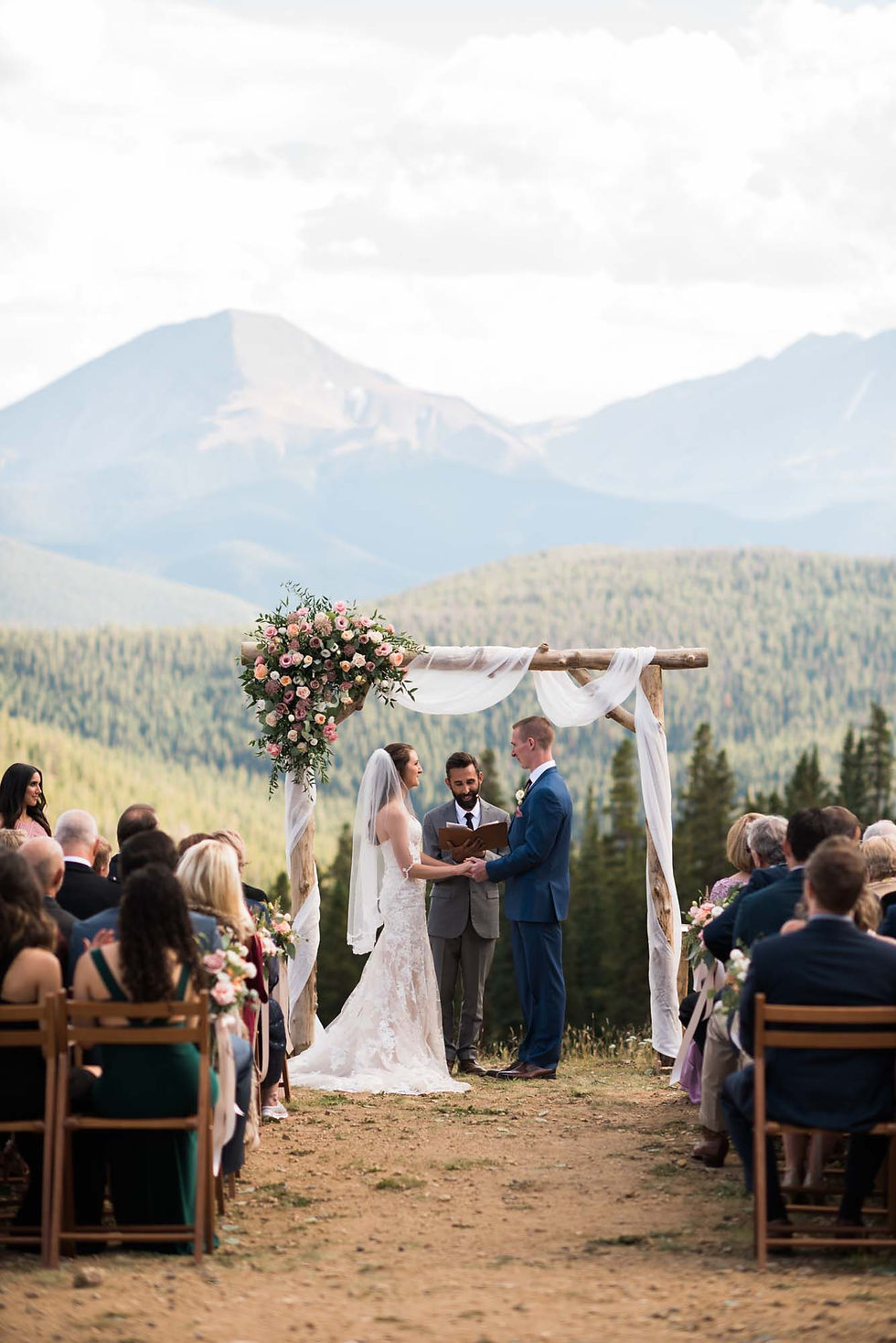 Bride and groom hold hands at the altar at Timber Ridge at Keystone Resort
