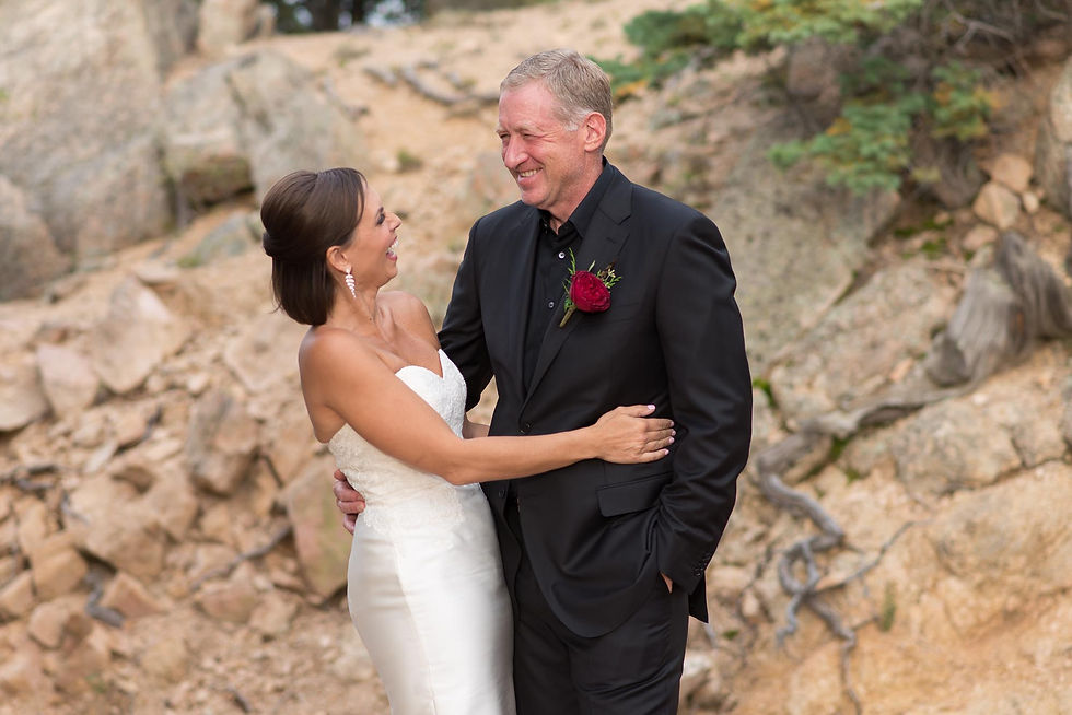 Bride and groom laugh together while posing outside at Cloud Camp at the Broadmoor