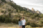 Man and woman smile at each other during Boulder, CO sunset engagement session