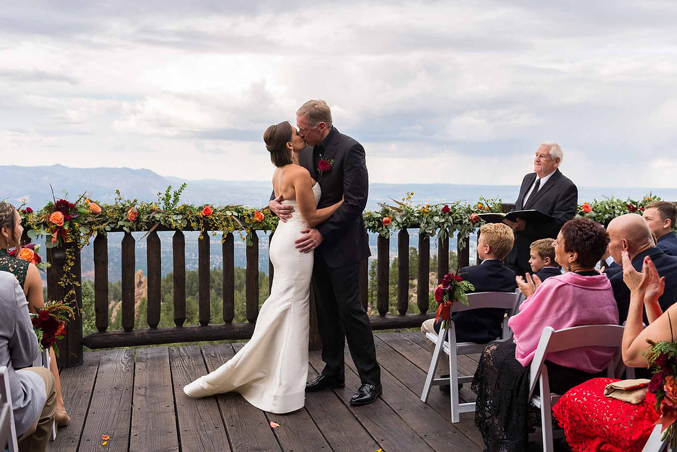 Bride and groom share their first kiss together on the outdoor deck at Cloud Camp at the Broadmoor