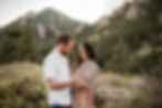 Man and woman laugh and hold hands during Boulder, CO sunset engagement session