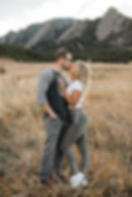 Man and woman kiss in front of mountains in Boulder, CO