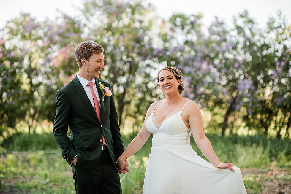 Bride and groom pose in front of lavender