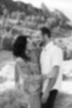 Man and woman look lovingly at each other during Boulder, CO sunset engagement session