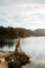 Man and woman stand on the edge of Evergreen Lake smiling at each other