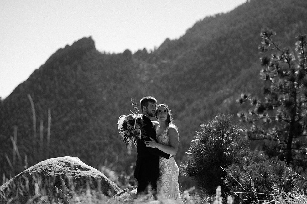 Bride and groom embrace as they overlook the flatirons
