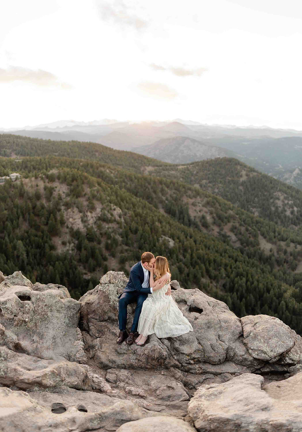 A man and woman kiss on top of Flagstaff Mountain in Boulder, CO