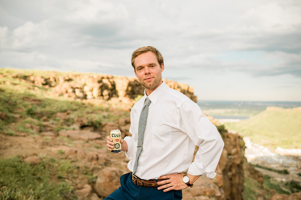 Groom poses with Coors beer during engagement session in Golden, CO