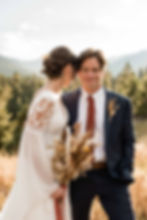 The bride nuzzles the groom while standing in a mountain valley at the Ranchstead Inn in Allenspark, CO