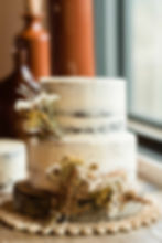 A white wedding cake with fall flowers as decorations