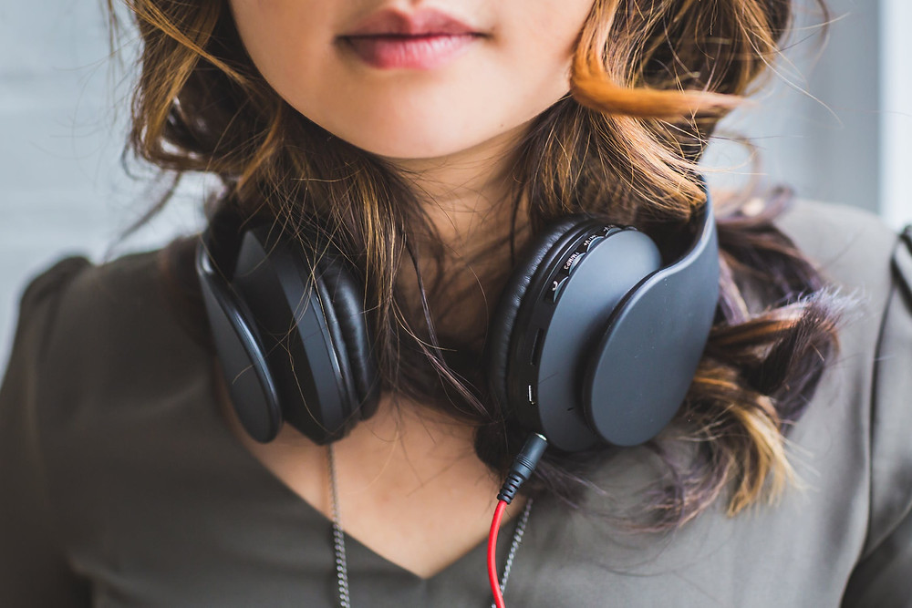 A girl with headphones around her neck.