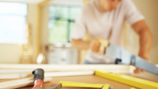 Child sawing wood representing life skills and carpentry programs for kids