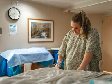 Woman laboring next to bed