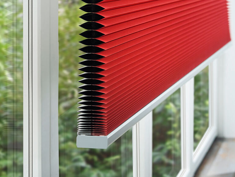 Maßgefertigtes Wabenplissee mit Thermostoff an einem großen Fenster für effektiven Hitze-, Kälte- und Sichtschutz.