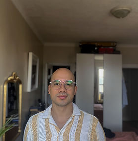Headshot of Rafael A Roa in Color wearing light purple glasses and striped shirt.