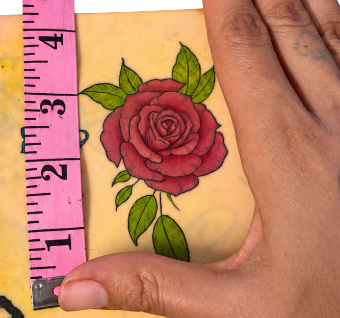 Tattoo practice pad with hand and tape.png