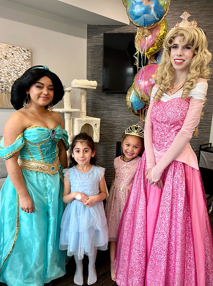 Jasmine and Aurora posed with a child for a birthday party