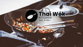 Ein brennender Wok bei der Zubereitung von frischem Thai Food mit dem Thai Wok Kitchen Logo im Vordergrund.