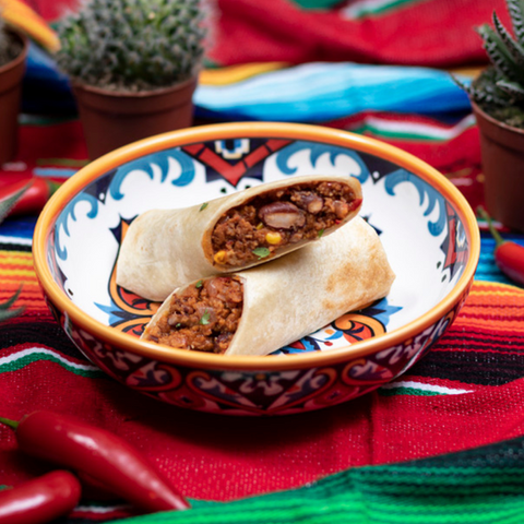 Aufgeschnittener Rinds-Burrito in einer Schale mit Salat und Saucen.