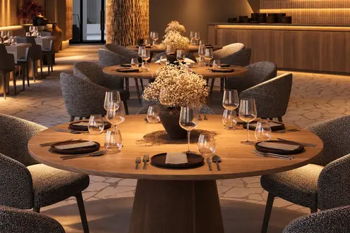 Tables rondes en bois naturel et fauteuils rembourrés dans un restaurant contemporain
