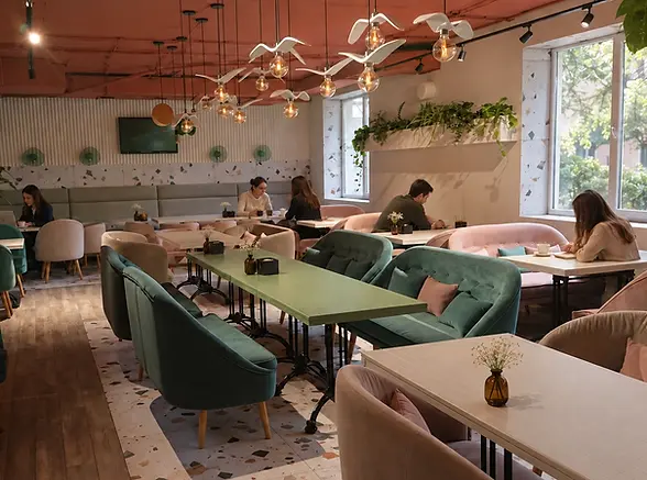 Aménagement intérieur d’un café avec tables, banquettes et fauteuils sur mesure