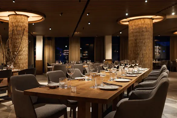 Grande table en bois sur mesure dans un restaurant à l’atmosphère chaleureuse