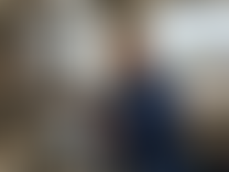 Heizungsinstallateur bei der Wartung einer Therme in einem Haus in Siegen; durch das Fenster ist die charakteristische Siegener Altstadt mit dem Oberen Schloss erkennbar