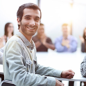 man-looks-camera-against-background-his-colleagues-sitting-table.jpg