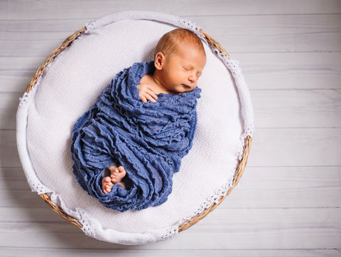 newborn-baby-enveloped-blue-scarf-sleeps-white-pillow.jpg