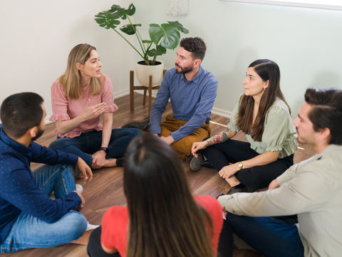 caucasian-woman-sharing-her-experience-with-addiction-with-her-rehab-group-young-member-at