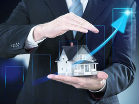 businessman-hand-holding-house-representing-home-ownership-real-estate-business-with-table