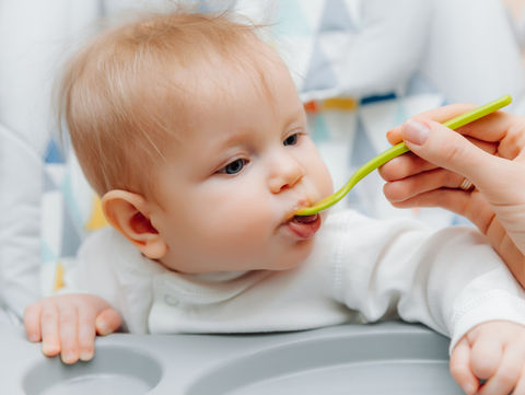 mother-gives-fruit-sauce-babymom-feeds-baby-highchairbaby-food.jpg